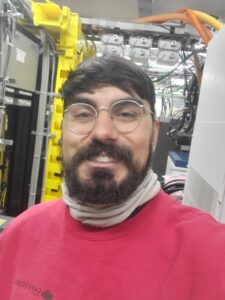 Bearded guy with glasses smiling in a rack room